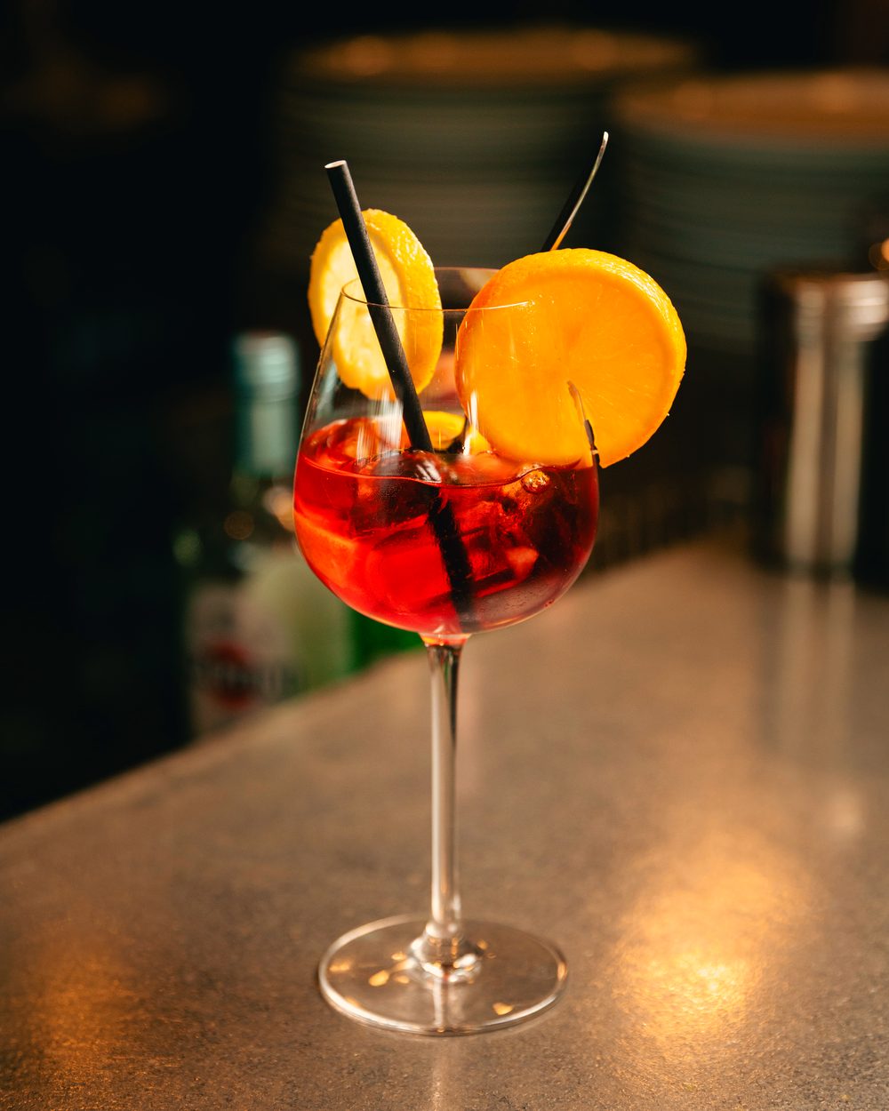 Spritz rouge orangé avec sa tranche d’orange.