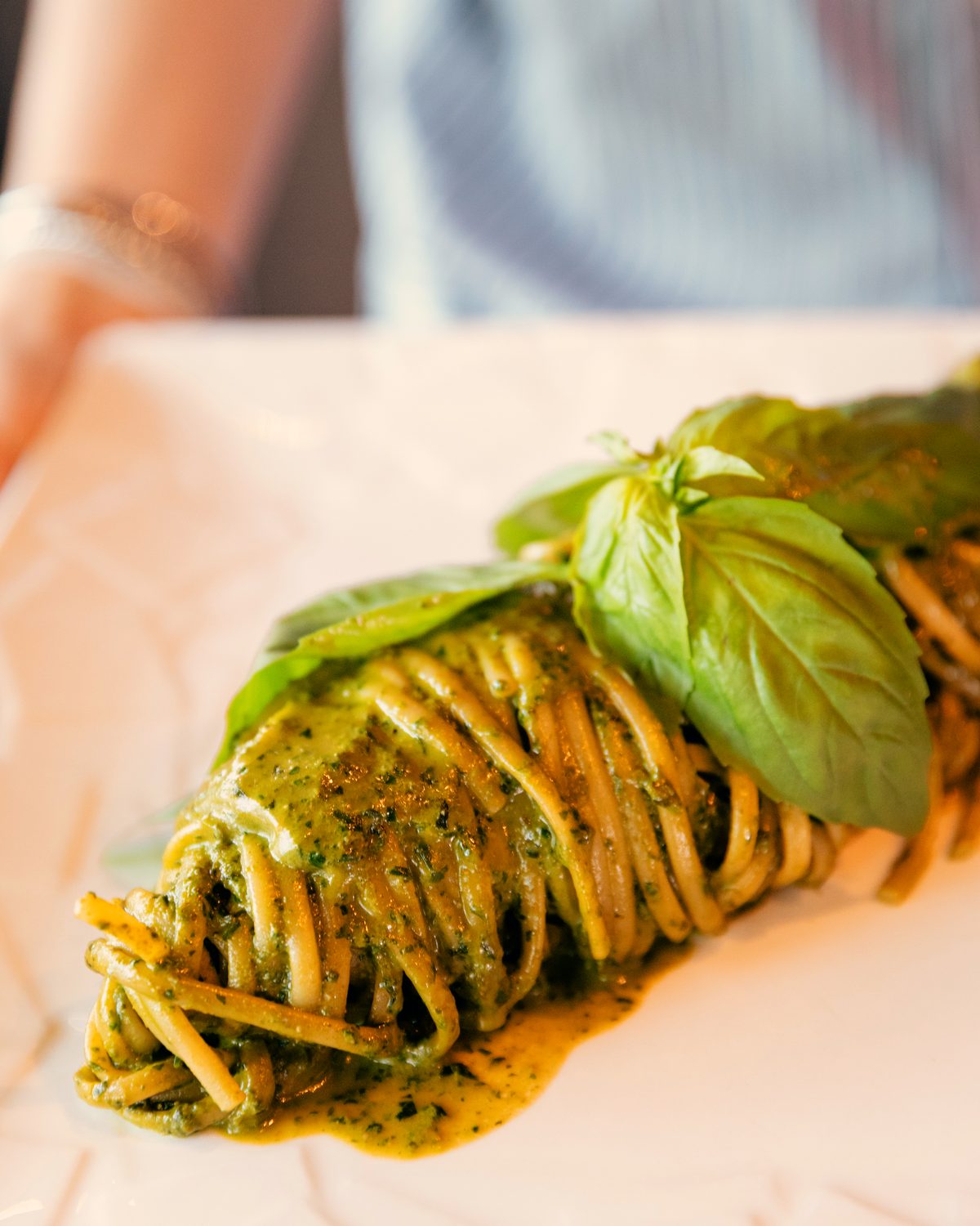 Linguini au pesto, feuilles de basilic frais posées sur l’assiette.