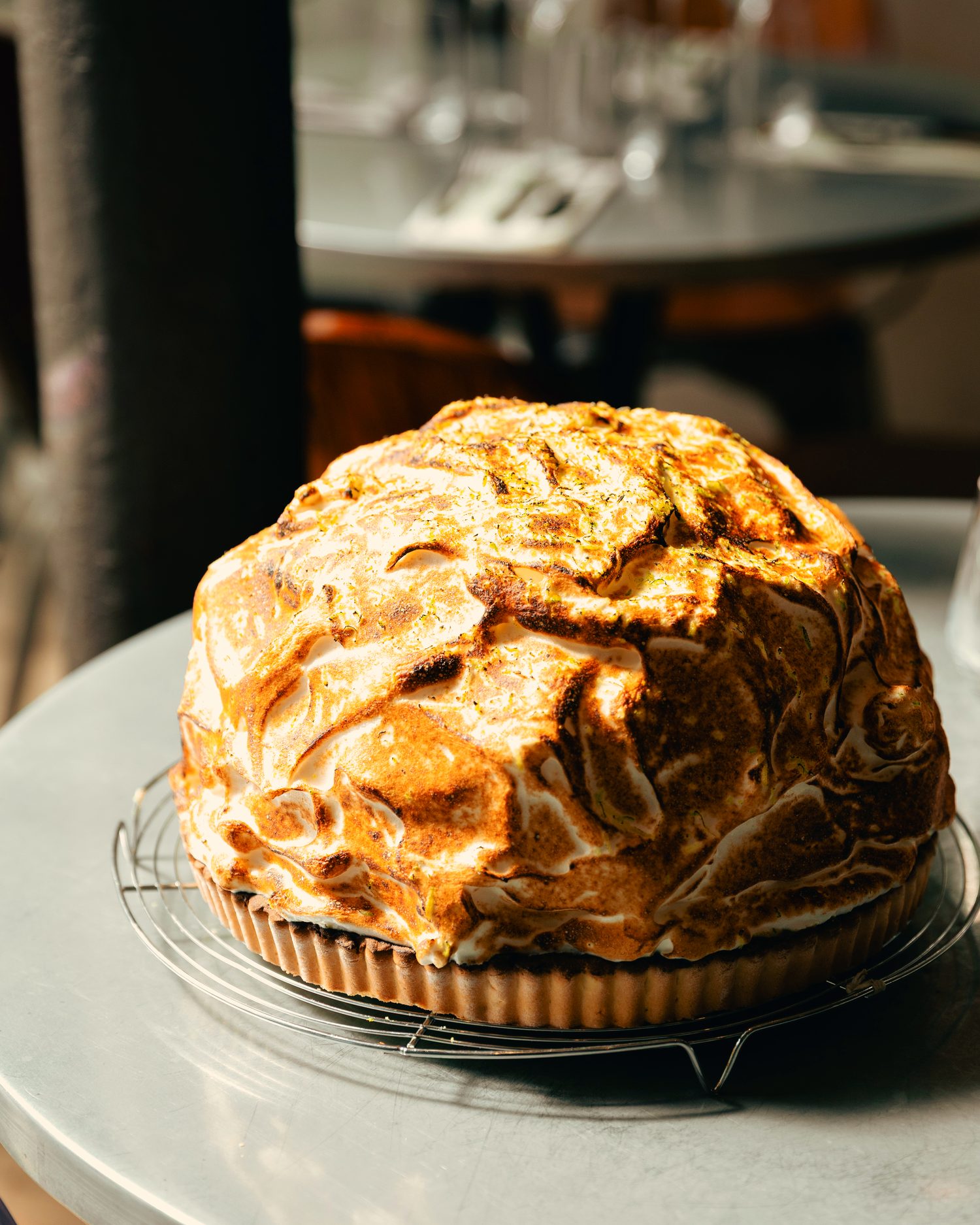 Tarte au citron entière recouverte d’une meringue très haute, posée sur le comptoir.